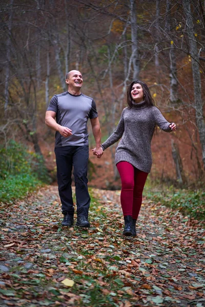 森の中の落ち葉で覆われた路地を歩いているカップル — ストック写真