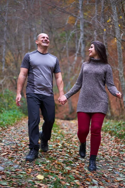 情侣们在林子里被落叶覆盖的小巷里散步 — 图库照片