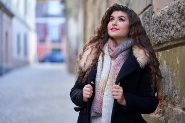 Şehir ortamında genç bir kadın, yaşlı bir kasaba.