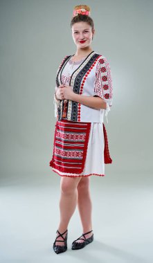 Popüler kostümlü genç Romen kadın, geleneksel müzik eşliğinde dans ediyor