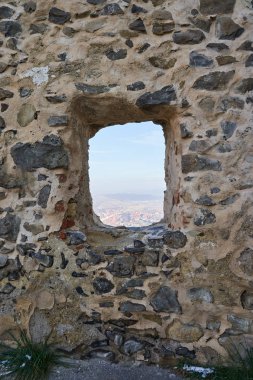 Şehrin üzerinde taş duvarları olan bir kalenin penceresinden bak.