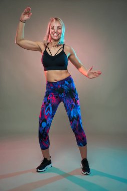 Spor mankeni aerobik yapıyor, dans ediyor, çekim yapıyor.