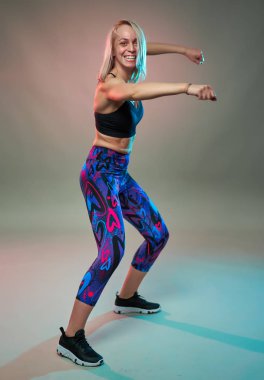 Spor mankeni aerobik yapıyor, dans ediyor, çekim yapıyor.