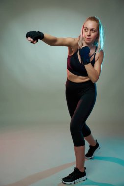 Kadın dövüşçü elleriyle gölge gibi boks yapıyor.