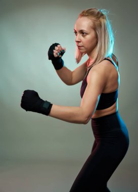 Kadın dövüşçü elleriyle gölge gibi boks yapıyor.