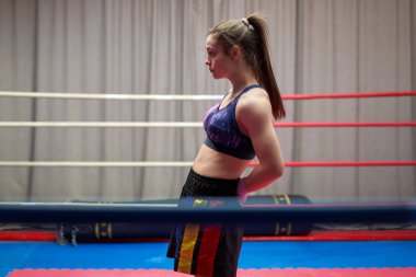 Kickbox dövüşçüsü kız antrenmandan önce geriniyor.