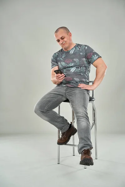 Bored Caucasian Man Using Cellphone While Sitting Tall Chair — Stok fotoğraf