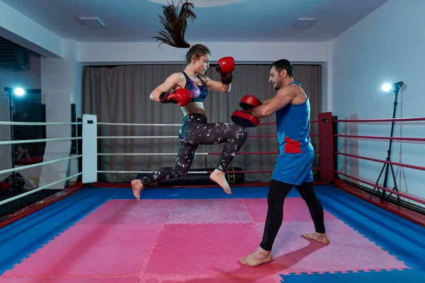 Kickboxer女孩和她的教练在拳击台上打手套 — 图库照片