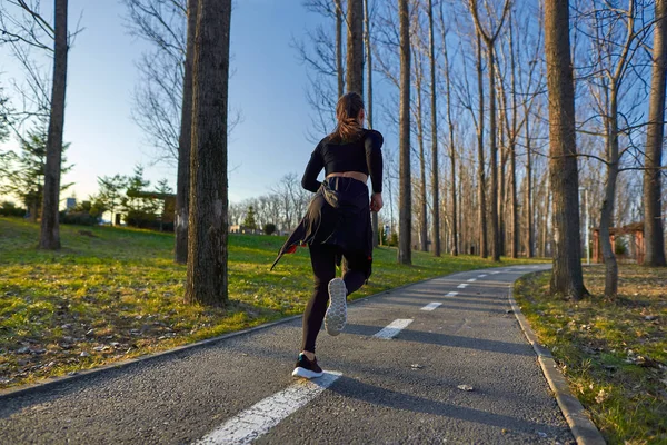 Parkta Koşan Eşofmanlı Atletik Bir Kadın — Stok fotoğraf