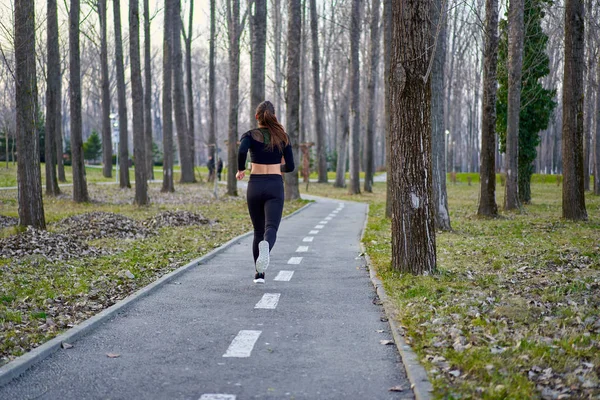 穿着运动服在公园里跑步的女运动员 — 图库照片