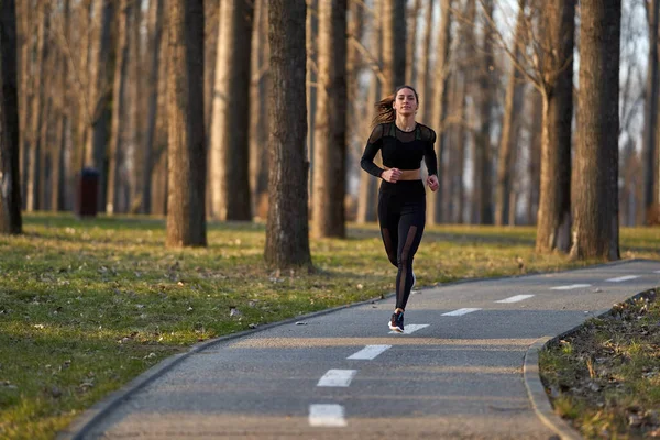 穿着运动服在公园里跑步的女运动员 — 图库照片