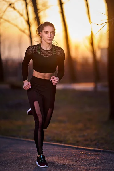 穿着运动服在公园里跑步的女运动员 — 图库照片