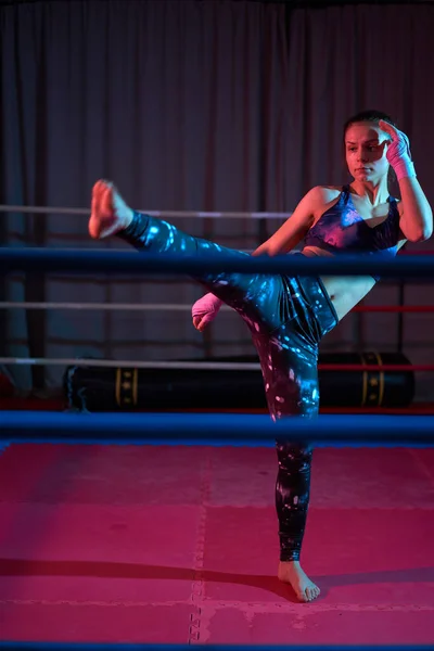 Kick-boxer girl training in ring