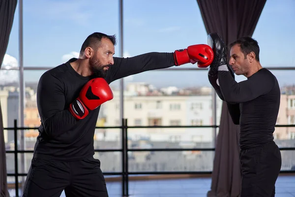 Boxer Schlägt Mit Seinem Trainer Der Turnhalle Auf Handschuhe Ein — Stockfoto