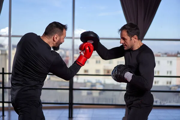Boxer Schlägt Mit Seinem Trainer Der Turnhalle Auf Handschuhe Ein — Stockfoto