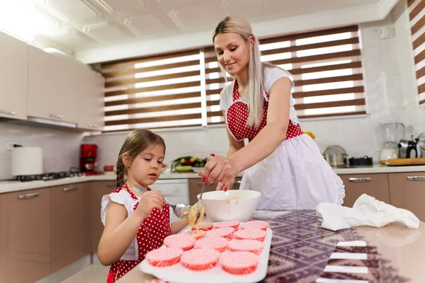 小さな女の子助けて彼女のお母さんでザ台所 — ストック写真