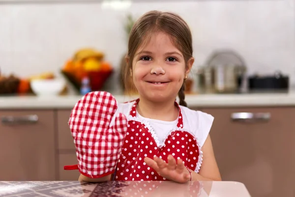 可爱的小女孩穿着围裙在厨房做饭 — 图库照片