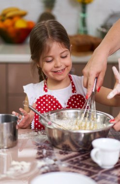 Genç kız ve annesi mutfakta eğleniyorlar.