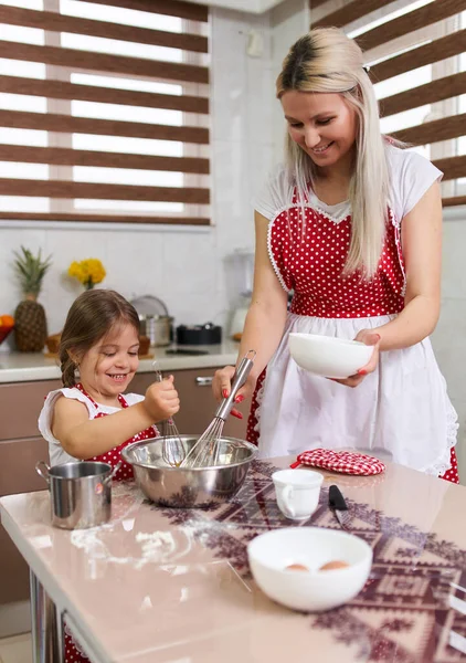小女孩和她妈妈在厨房里玩得很开心 图库图片