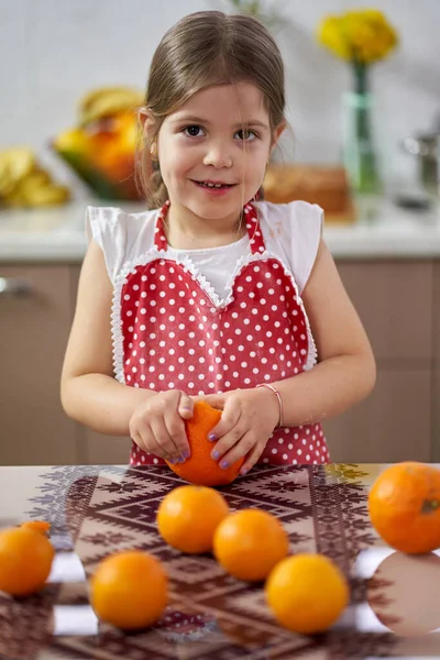 Fiatal Lány Peeling Narancs Konyhában — Stock Fotó