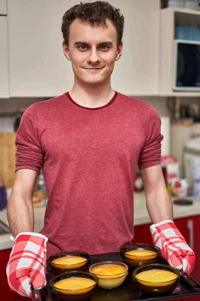 Orgoglioso Giovane Uomo Che Presenta Vassoio Con Creme Brulee Appena — Foto Stock