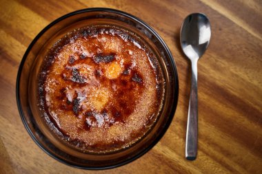 Creme brulee, ahşap bir tahtanın üzerinde lezzetli bir Fransız tatlısıdır.