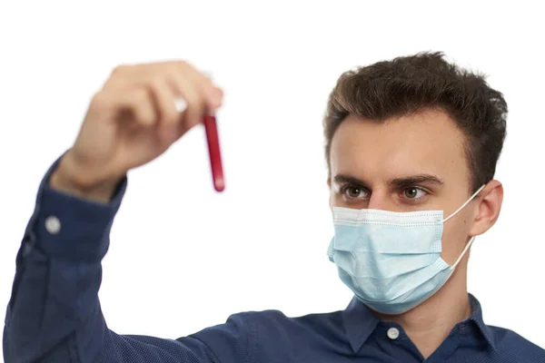 血液サンプルと試験管を保持保護マスクを持つ若い男 — ストック写真