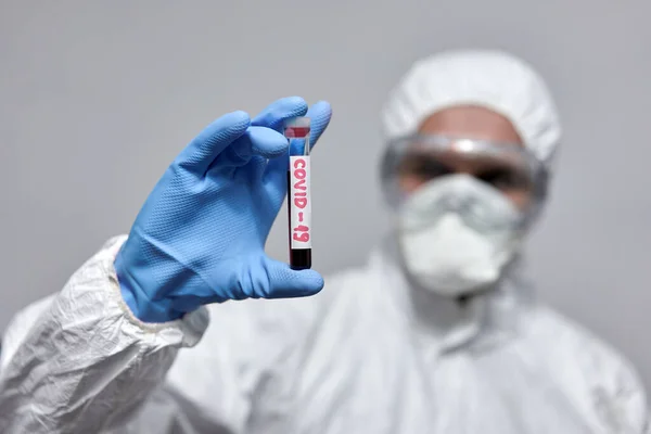 医師は コロナウイルスのための試験管と全体的な保護スーツ — ストック写真