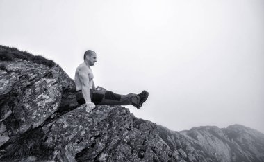 Muhteşem bir dağ manzarasında egzersiz yapan aktif bir adam.