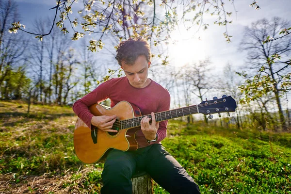 若い男は屋外でギターを演奏 — ストック写真