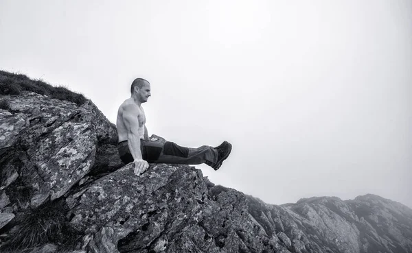 Muhteşem bir dağ manzarasında egzersiz yapan aktif bir adam.