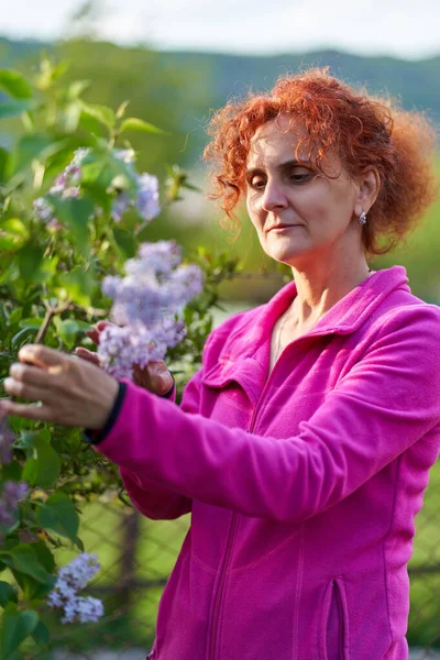 Güzel kıvırcık saçlı kadın leylak çalılığında