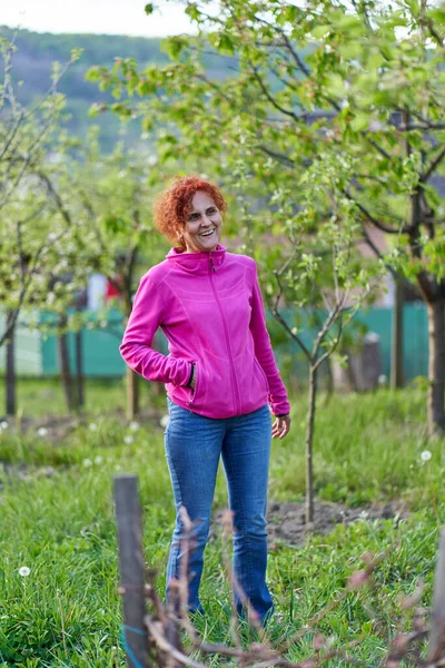 Kızıl Saçlı Kıvırcık Saçlı Kadın Elma Ağaçlarının Bahçesinde — Stok fotoğraf