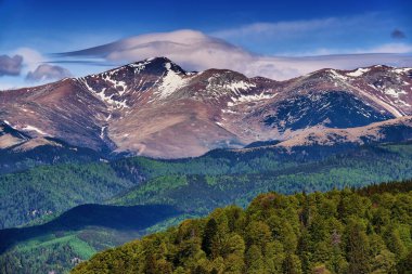 Yazın dağlarla kaplı manzara, hala kar parçaları var.