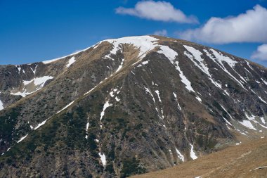 Yazın dağlarla kaplı manzara, hala kar parçaları var.