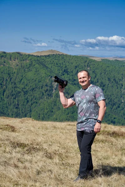 Tourist with camera hiking on a mountain trail