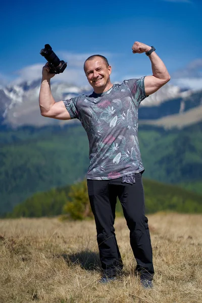 Dağ yolunda yürüyen kameralı bir turist.