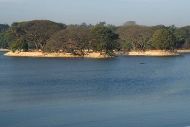 Yeşil ağaçlar ortasında mavi göl ve gökyüzü