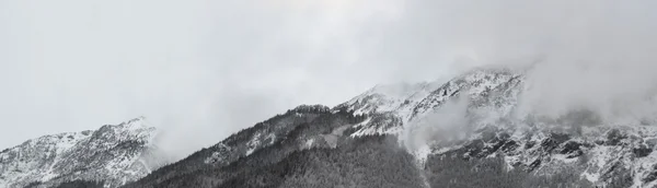 雪と雲によって覆われたピークを持つアルプスの風景 — ストック写真