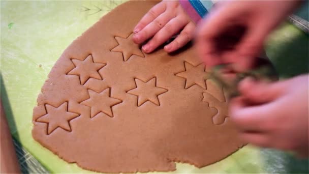 Mädchen schneidet Weihnachtsplätzchen aus Teig. Koch backt Plätzchen in verschiedenen Formen. — Stockvideo