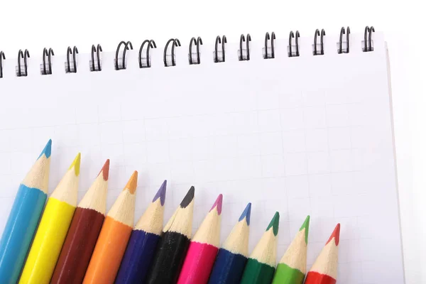 Obraz notebooku a barevné tužky, detail, izolované — Stock fotografie