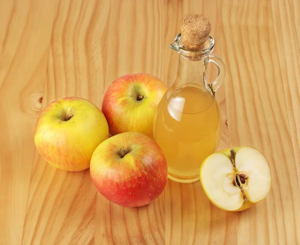 Apple cider vinegar and fresh apple on a wooden background — Stock Photo, Image