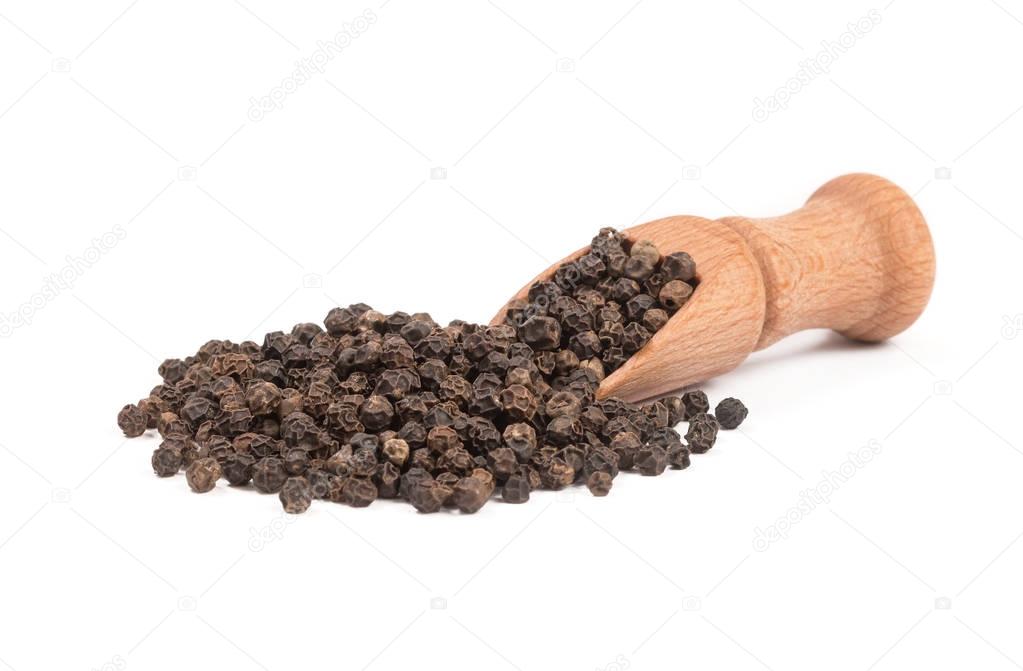 Black pepper in a wooden spoon isolated