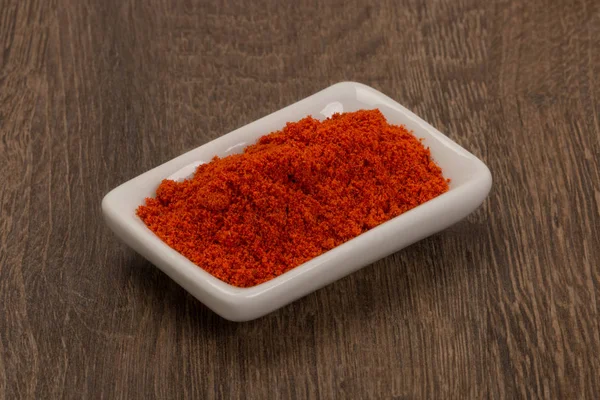 Red pepper powder over wood background — Stock Photo, Image