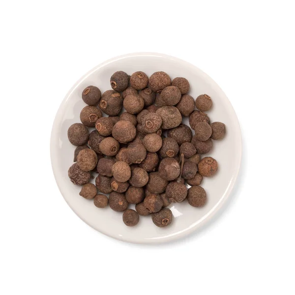 Seeds of allspice in a white bowl on a white background — Stock Photo, Image