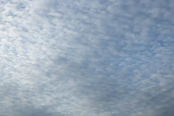Blå himmel bakgrund med små moln Stockfoto