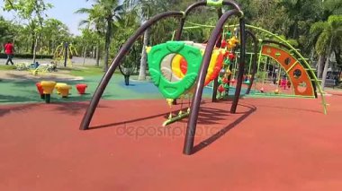 Güneşli bir günde halka açık parktaki oyun alanına koşun.