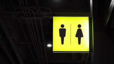 Kare ışık kutusu tuvaleti tabelası duvarda asılı.
