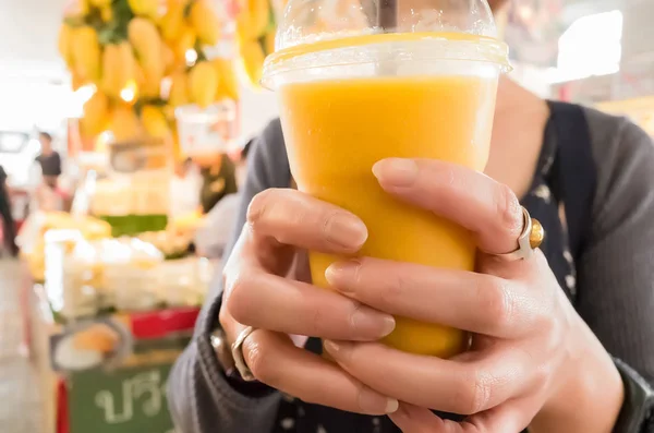 Woman hold a mango juice — Stock Photo, Image