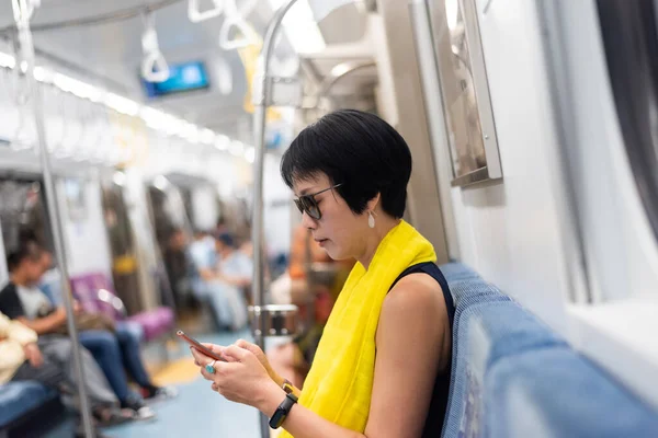 Woman using smartphone at the MRT carriage — Stock Photo, Image